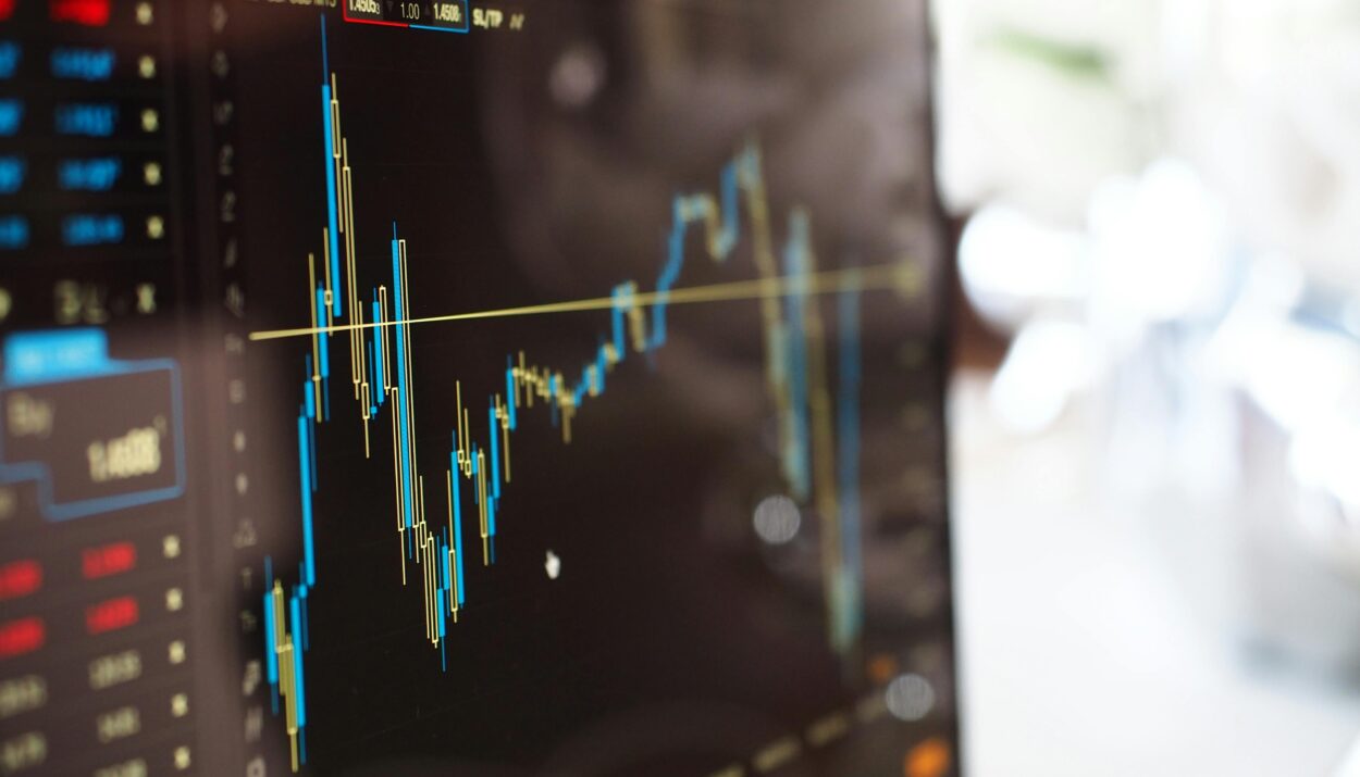 Detailed view of financial trading graphs on a monitor, illustrating stock market trends.