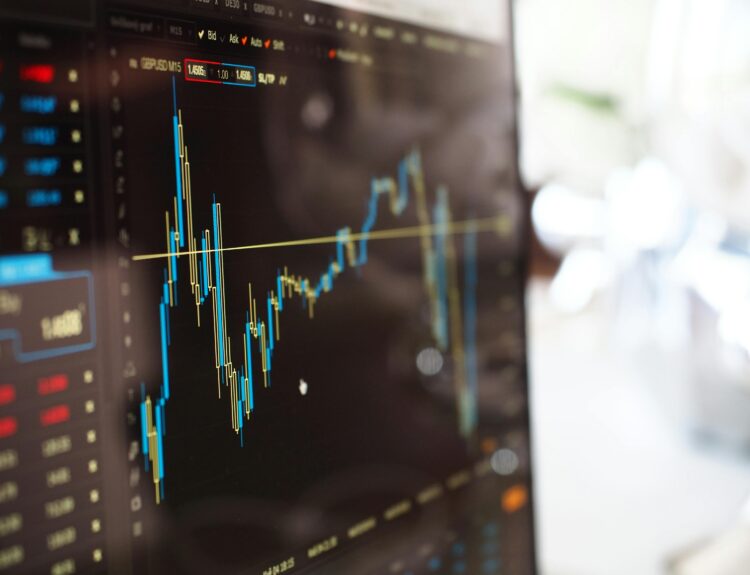Detailed view of financial trading graphs on a monitor, illustrating stock market trends.